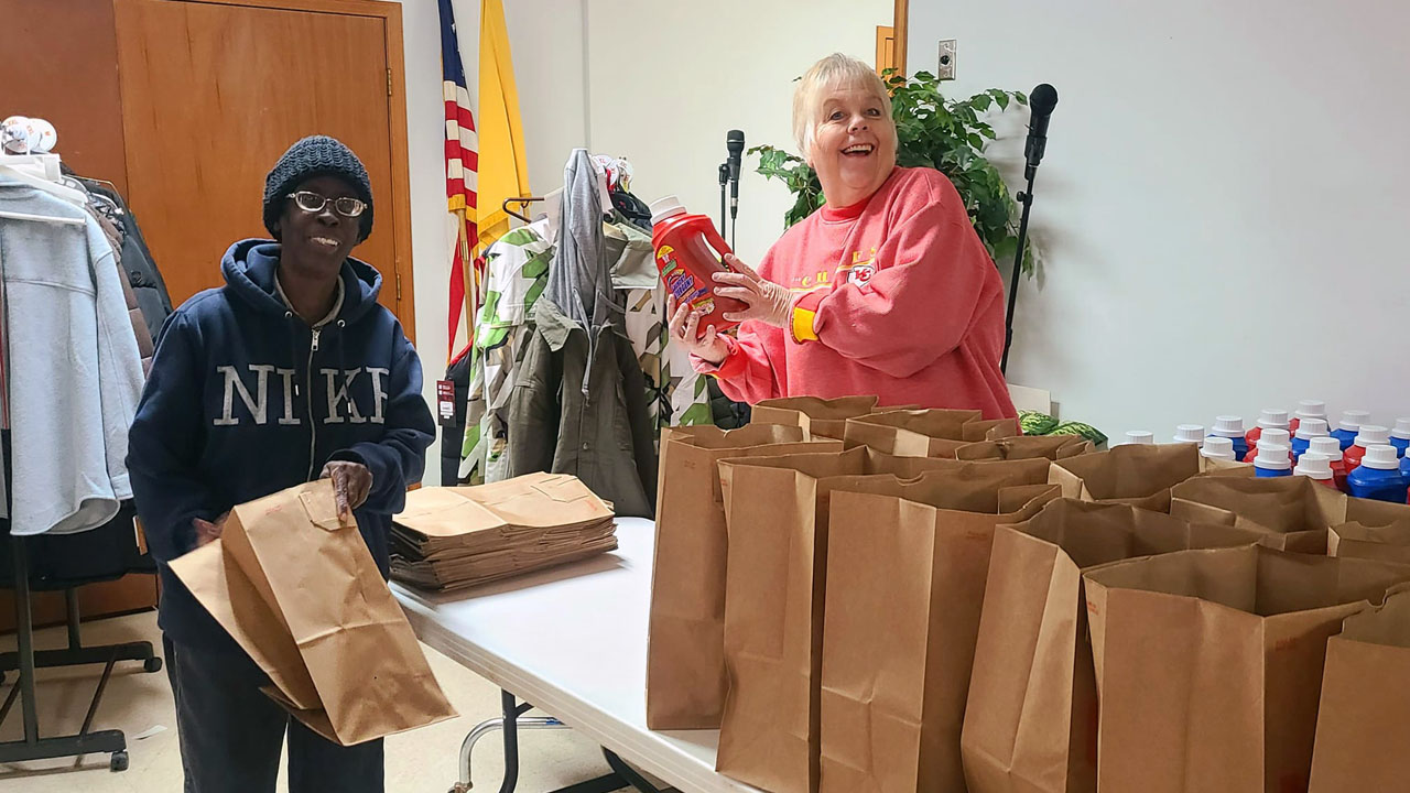 A community and parish volunteer work together to prepare donation bags for the annual Christmas Baskets program at St. Therese Little Flower Parish.