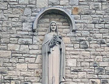 The statue of St. Therese Little Flower fixed on the front of the St. Therese Little Flower Catholic Church.