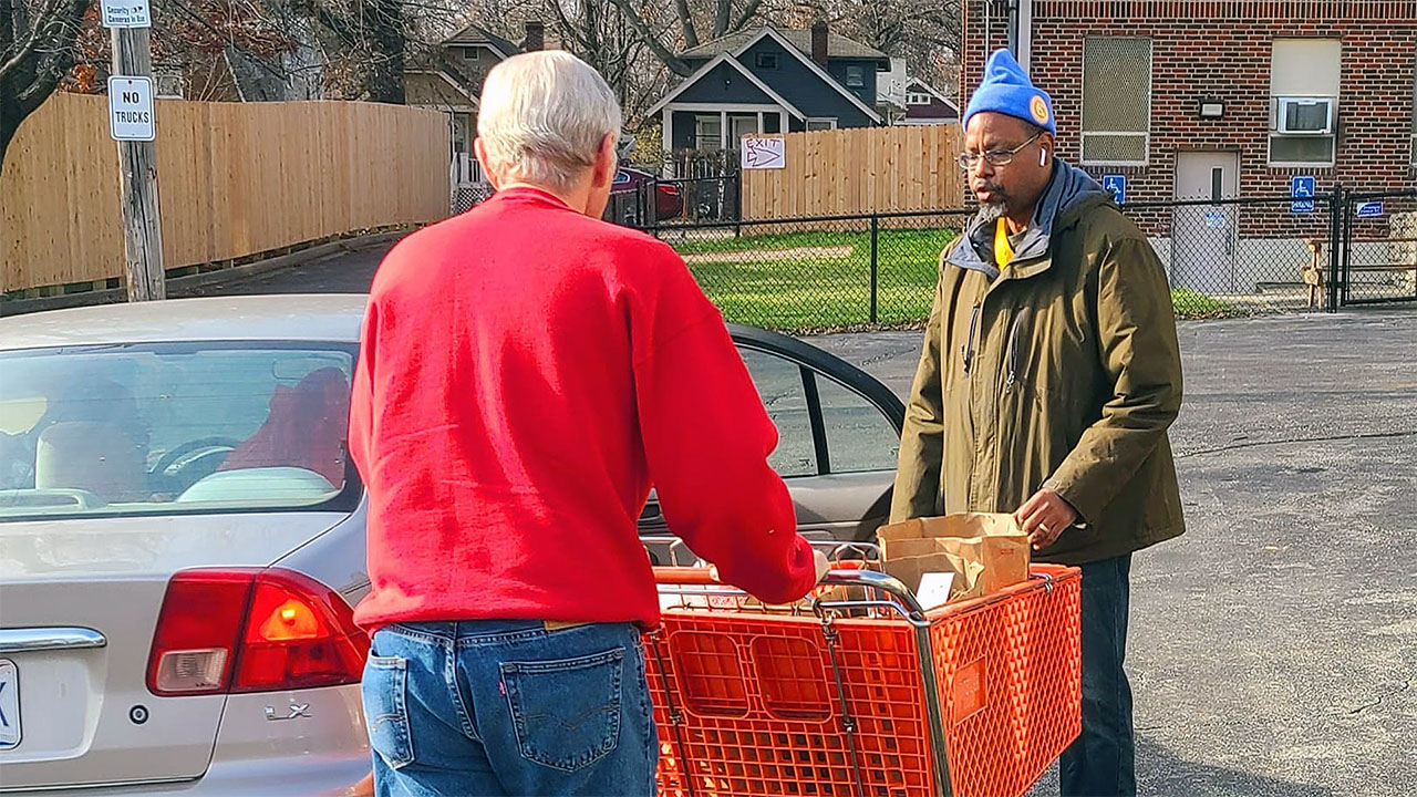 A St. Therese Little Flower Food Pantry volunteer delivering groceries to a family in need.